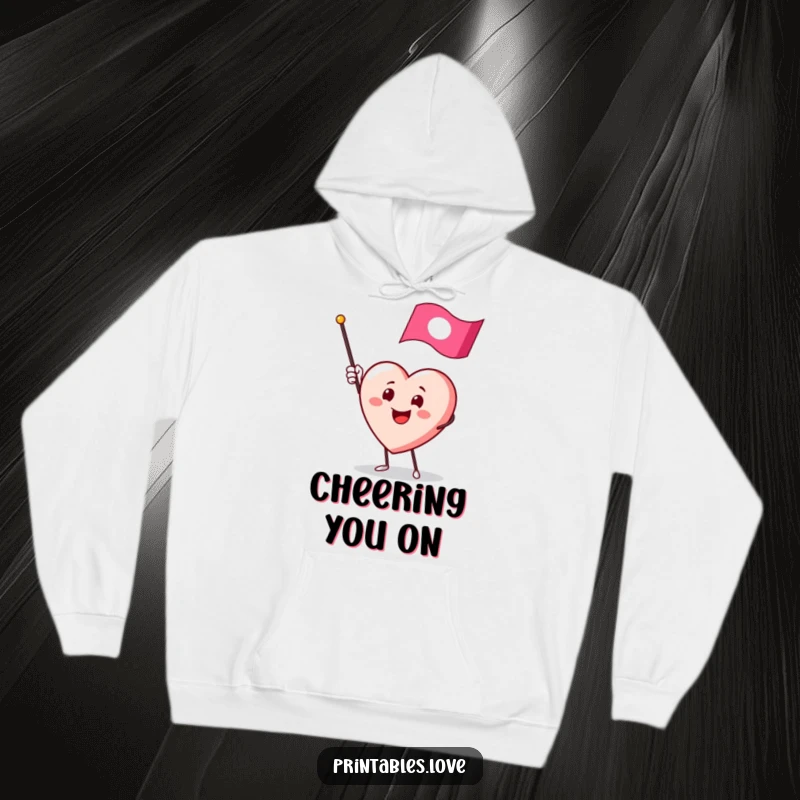Funny hoodie with a smiling heart character enthusiastically waving a miniature flag, perfect for cozy, cheerful days.